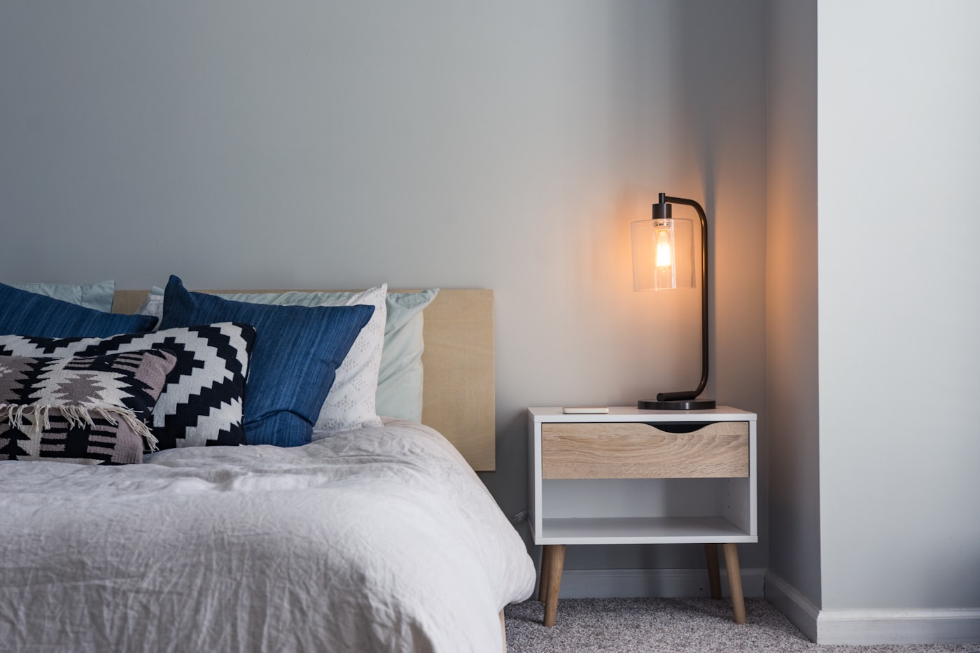 Opgemaakt bed met kussens in een sfeervolle slaapkamer